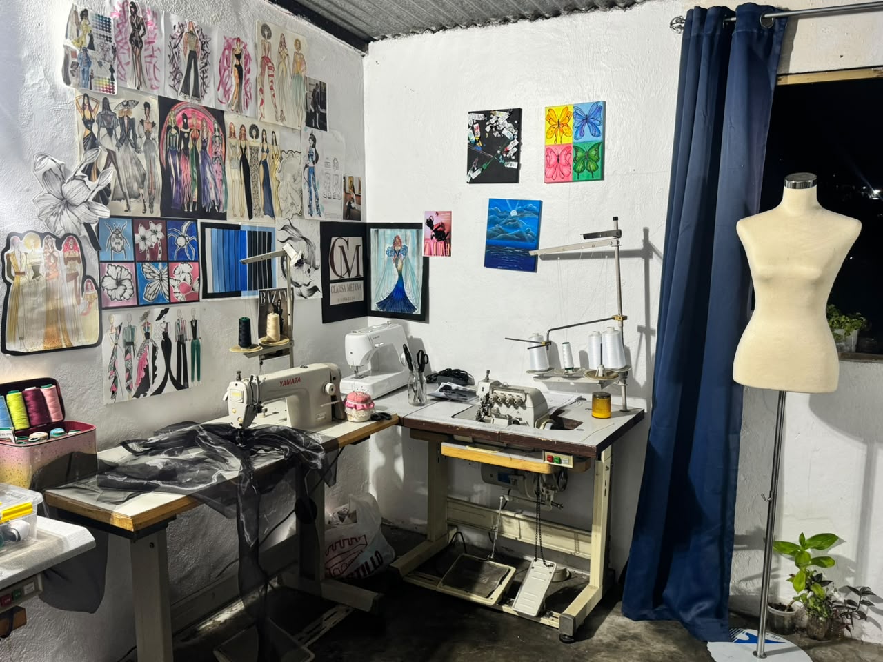 El taller de Clarisa Medina: máquinas de coser, maniquí y la pared cubierta de figurines